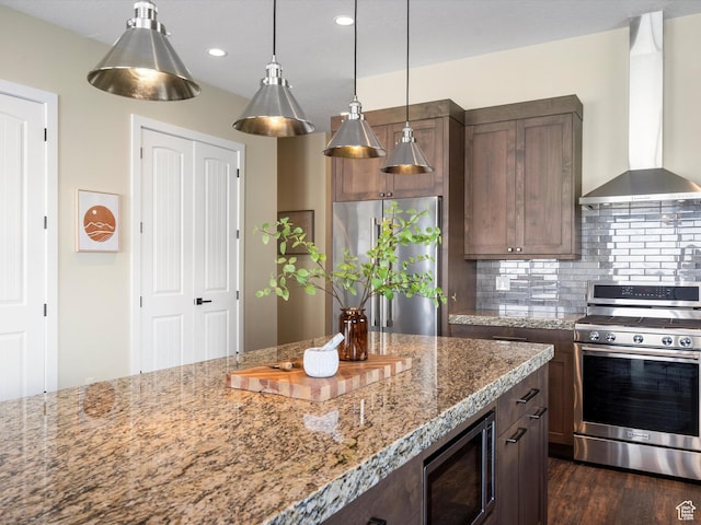 5943 E Big Horn Pkwy, Eden, UT 84310 - kitchen featuring appliances with stainless steel finishes, wall chimney exhaust hood, decorative backsplash, light stone countertops, and recessed lighting