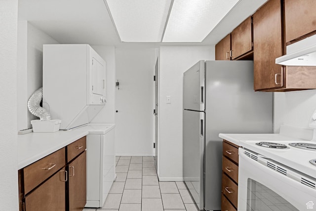 207 S 600 E Unit 3C, Salt Lake City, UT 84102 - kitchen with white electric stove, stacked washer / dryer, light countertops, exhaust hood, and light tile patterned flooring