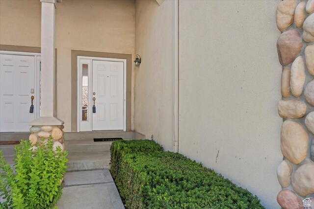 7825 S Spruce Tree Ln, Sandy, UT 84094 - view of exterior entry featuring stucco siding
