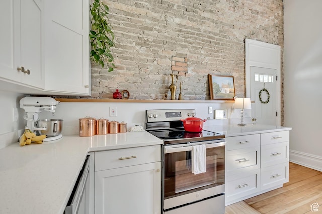 119 E 400 S, Provo, UT 84606 - kitchen featuring stainless steel electric range oven, brick wall, white cabinetry, light countertops, and light wood-style floors