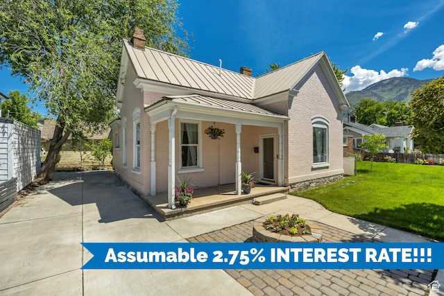 119 E 400 S, Provo, UT 84606 - view of front of property featuring a standing seam roof, a chimney, brick siding, and covered porch