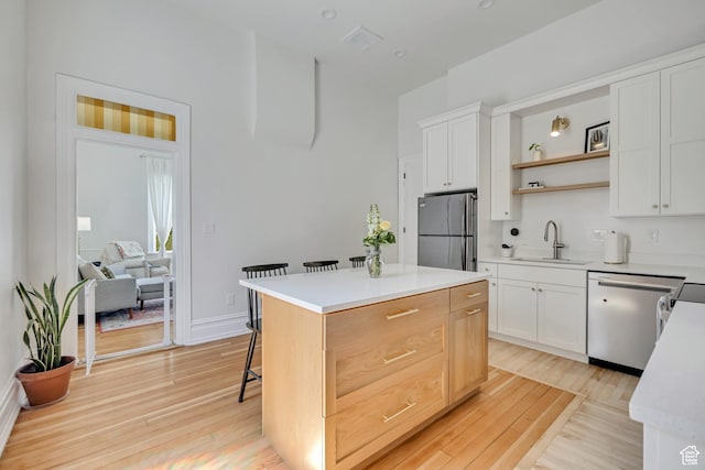 119 E 400 S, Provo, UT 84606 - kitchen featuring appliances with stainless steel finishes, a sink, light wood-style flooring, and a breakfast bar area
