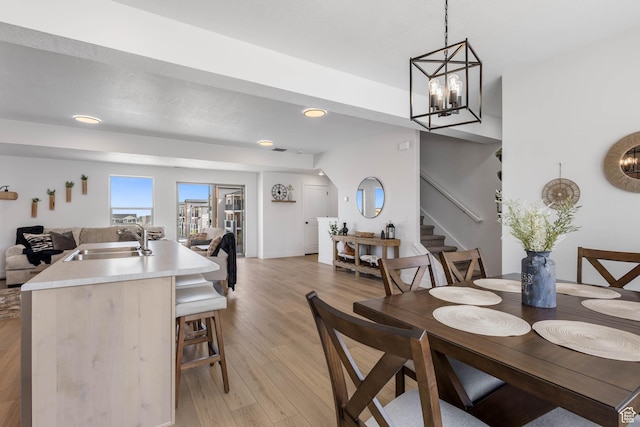 606 W Caroles Way, Tooele, UT 84074 - dining area featuring light wood finished floors, stairway, recessed lighting, and a chandelier