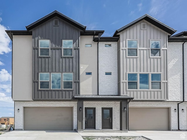 606 W Caroles Way, Tooele, UT 84074 - view of front of house with an attached garage, board and batten siding, concrete driveway, and brick siding