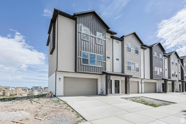 606 W Caroles Way, Tooele, UT 84074 - view of property featuring an attached garage, concrete driveway, a residential view, and brick siding