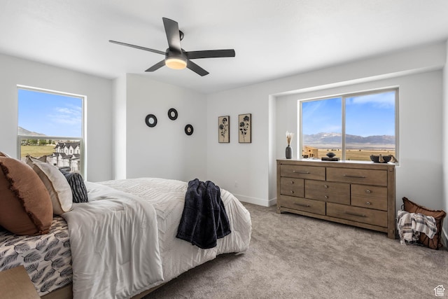 606 W Caroles Way, Tooele, UT 84074 - bedroom with light colored carpet, multiple windows, ceiling fan, and a mountain view