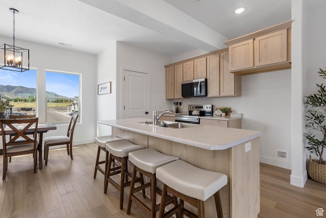 606 W Caroles Way, Tooele, UT 84074 - kitchen featuring stainless steel appliances, light brown cabinetry, a sink, light countertops, and baseboards