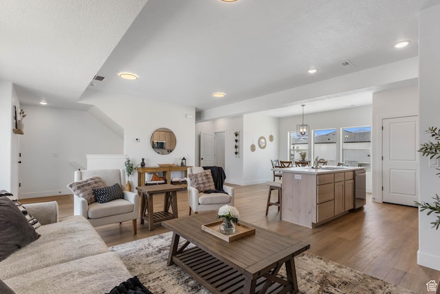 606 W Caroles Way, Tooele, UT 84074 - living room featuring light wood-type flooring, recessed lighting, and baseboards