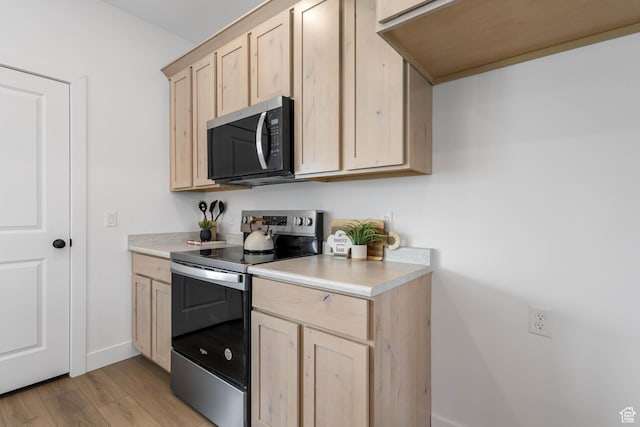606 W Caroles Way, Tooele, UT 84074 - kitchen with stainless steel appliances, light brown cabinetry, light countertops, and light wood-type flooring