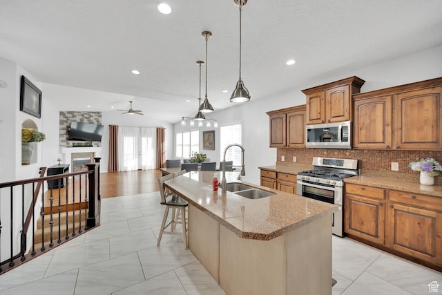 14789 S Briar Park Rd W, Herriman, UT 84096 - kitchen featuring appliances with stainless steel finishes, a sink, a ceiling fan, open floor plan, and light stone counters