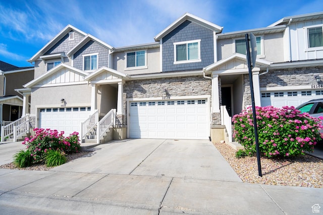 14508 S Juniper Shade Dr W, Herriman, UT 84096 - view of front of home featuring stone siding, driveway, board and batten siding, stucco siding, and a garage