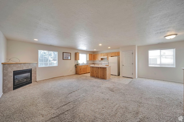 1588 N Dawson W, Tooele, UT 84074 - unfurnished living room with recessed lighting, a fireplace, light carpet, a textured ceiling, and baseboards