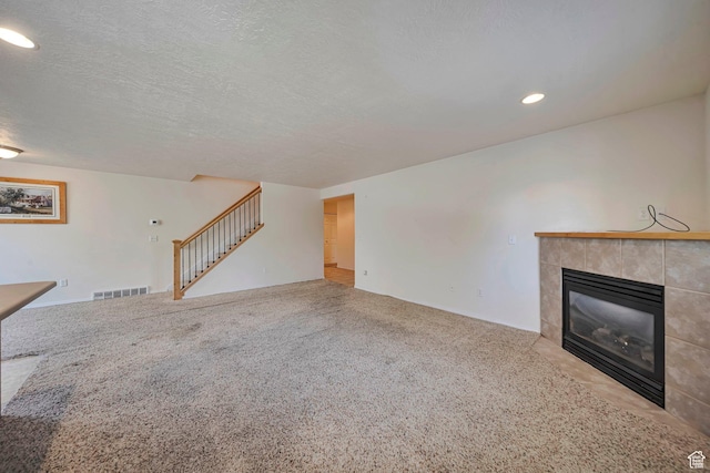 1588 N Dawson W, Tooele, UT 84074 - unfurnished living room featuring stairs, a tile fireplace, carpet floors, recessed lighting, and baseboards