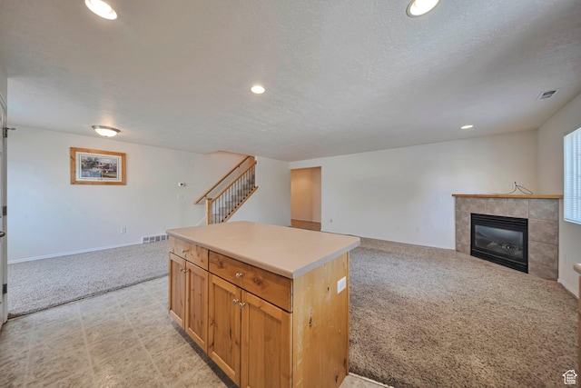 1588 N Dawson W, Tooele, UT 84074 - kitchen featuring open floor plan, a kitchen island, recessed lighting, a tiled fireplace, and light carpet