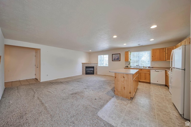 1588 N Dawson W, Tooele, UT 84074 - kitchen featuring white appliances, recessed lighting, light countertops, a tile fireplace, and light colored carpet