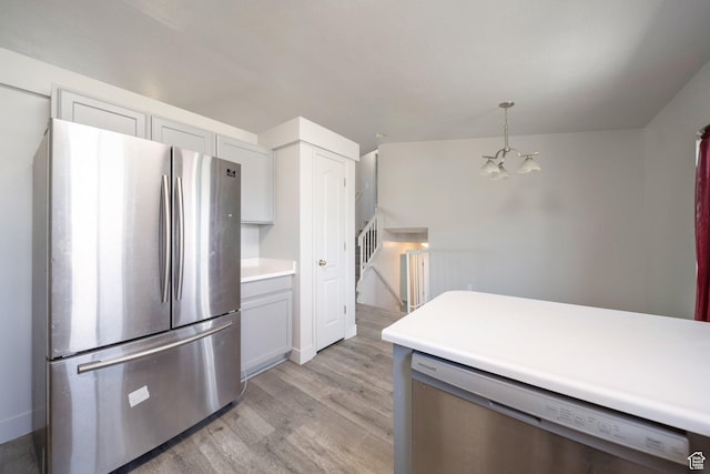 1454 N 420 E, Tooele, UT 84074 - kitchen with appliances with stainless steel finishes, light wood-style floors, a chandelier, light countertops, and decorative light fixtures