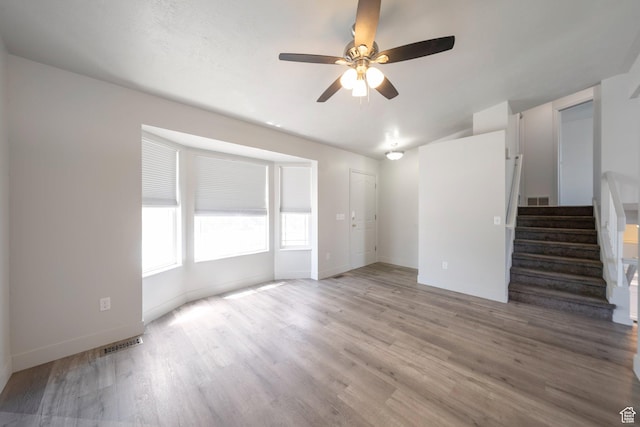 1454 N 420 E, Tooele, UT 84074 - unfurnished living room featuring stairs, ceiling fan, light wood-style flooring, and baseboards