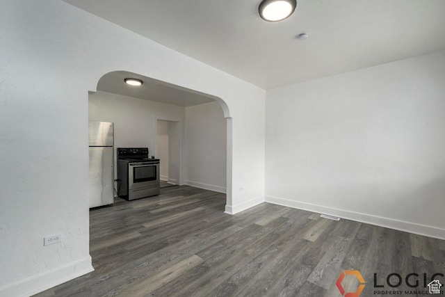 2743 Liberty Ave, Ogden, UT 84403 - unfurnished living room with arched walkways, dark wood-style floors, and baseboards