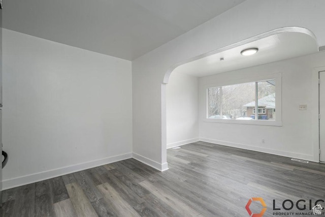 2743 Liberty Ave, Ogden, UT 84403 - unfurnished room featuring arched walkways, dark wood-type flooring, and baseboards