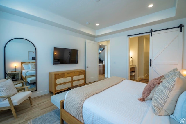 3780 Arcadia Dr Unit 53, Santa Clara, UT 84765 - bedroom featuring a barn door, light wood-style floors, a tray ceiling, recessed lighting, and baseboards