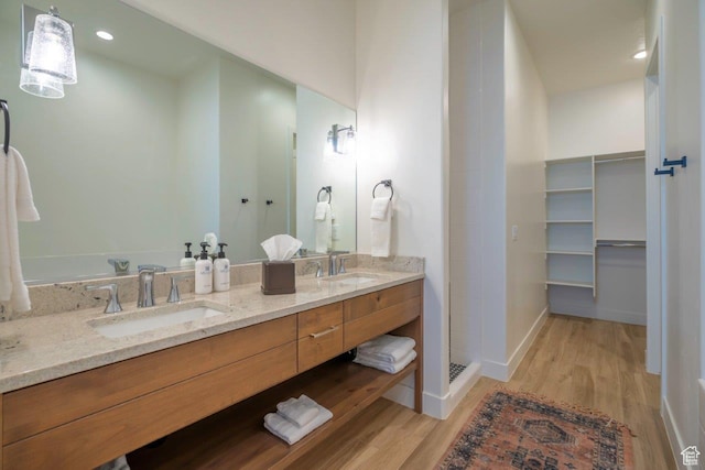 3780 Arcadia Dr Unit 53, Santa Clara, UT 84765 - bathroom featuring wood finished floors, double vanity, baseboards, walk in shower, and recessed lighting