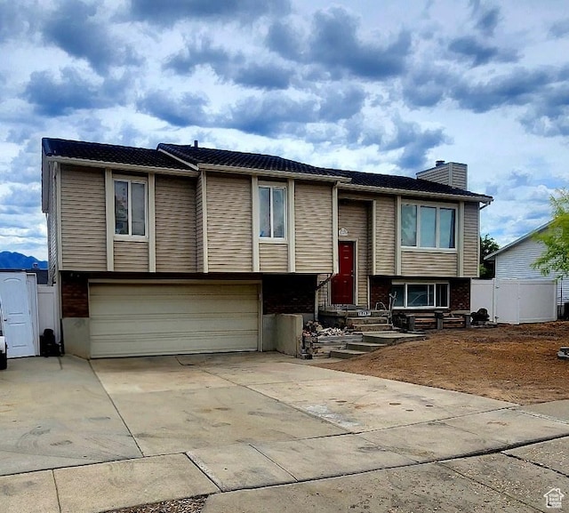 5649 S Bree St W, Taylorsville, UT 84129 - split foyer home featuring an attached garage, a chimney, and concrete driveway