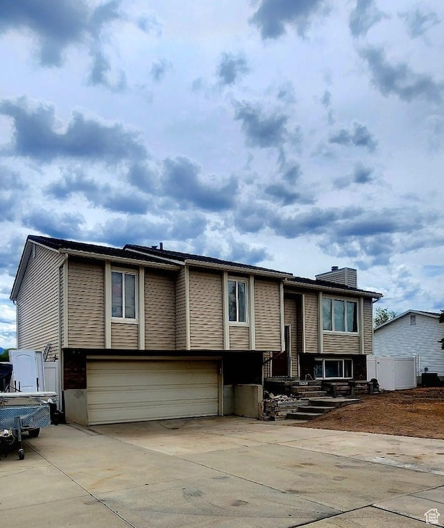 5649 S Bree St W, Taylorsville, UT 84129 - bi-level home with an attached garage and concrete driveway