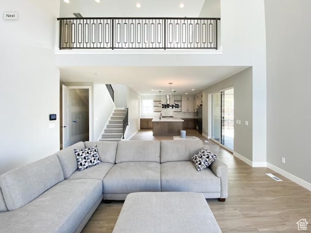 1594 W Canyon Rim N Unit 609, Lehi, UT 84043 - living area featuring plenty of natural light, a towering ceiling, stairway, recessed lighting, and baseboards