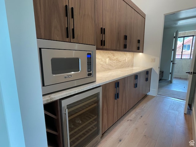101 Crestview Cir, Park City, UT 84098 - kitchen featuring stainless steel microwave, beverage cooler, tasteful backsplash, light wood-style flooring, and light stone countertops