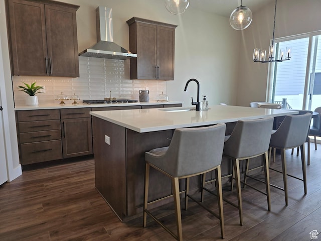 3577 W Haven Hollow Dr S, South Jordan, UT 84095 - kitchen with wall chimney range hood, a sink, a center island with sink, and backsplash