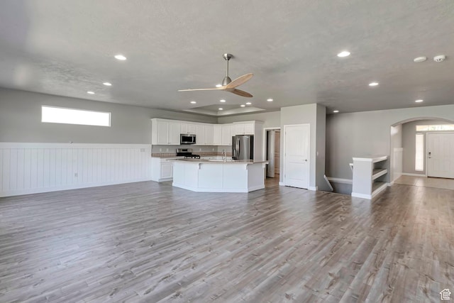 2832 N Turnberry Ln, Lehi, UT 84043 - unfurnished living room featuring ceiling fan, a sink, recessed lighting, arched walkways, and light wood-style flooring