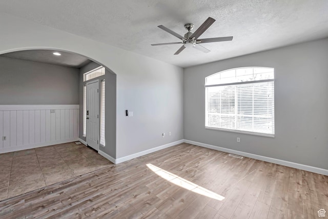 2832 N Turnberry Ln, Lehi, UT 84043 - spare room featuring arched walkways, a textured ceiling, wood finished floors, ceiling fan, and baseboards