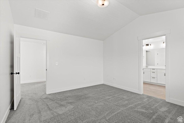 12361 S Xander Ln, Herriman, UT 84096 - unfurnished bedroom with light carpet, lofted ceiling, baseboards, and connected bathroom