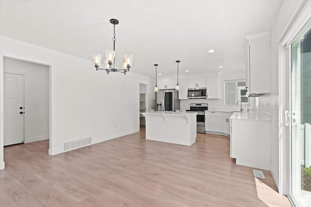 12361 S Xander Ln, Herriman, UT 84096 - kitchen featuring appliances with stainless steel finishes, a sink, a chandelier, a breakfast bar area, and light countertops
