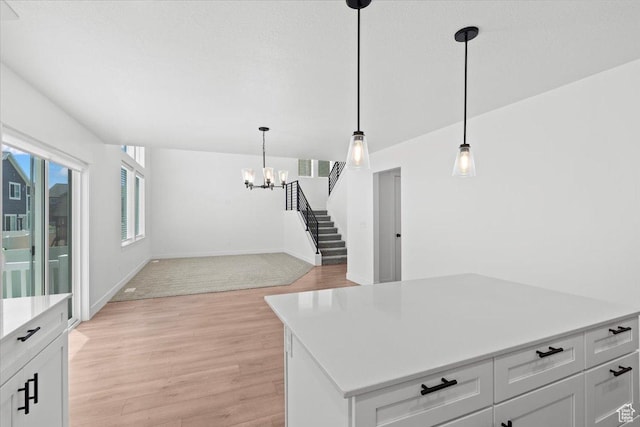 12361 S Xander Ln, Herriman, UT 84096 - kitchen with light wood-style flooring, light countertops, a chandelier, decorative light fixtures, and white cabinets
