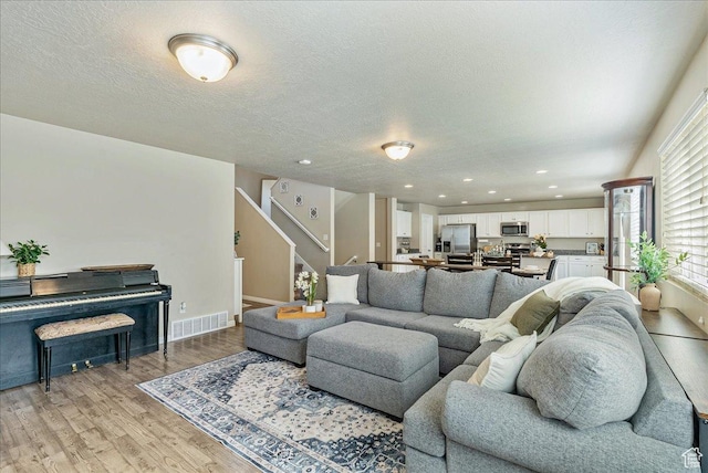 204 E 460 N, Vineyard, UT 84059 - living room with light wood-type flooring, stairway, baseboards, a textured ceiling, and recessed lighting