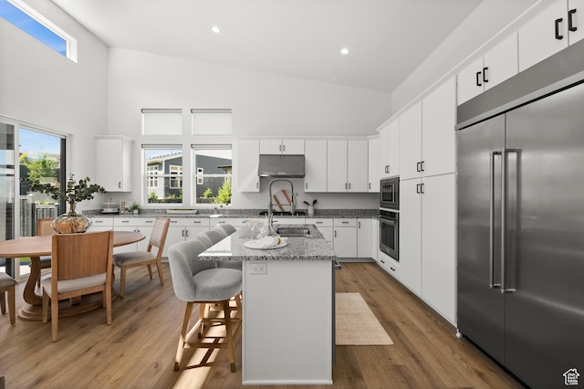 5472 N Valley View Rd W, Lehi, UT 84043 - kitchen with built in appliances, high vaulted ceiling, a center island with sink, plenty of natural light, and white cabinets