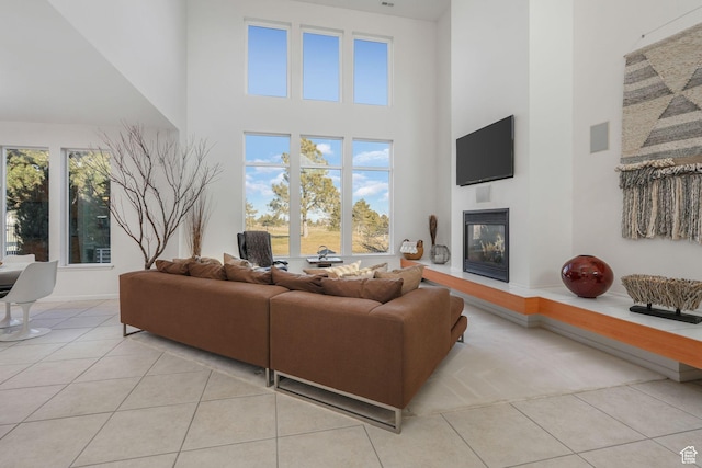 4554 W Birdie Way S, Jordan, UT 84009 - living area with a towering ceiling, tile patterned flooring, a glass covered fireplace, and plenty of natural light