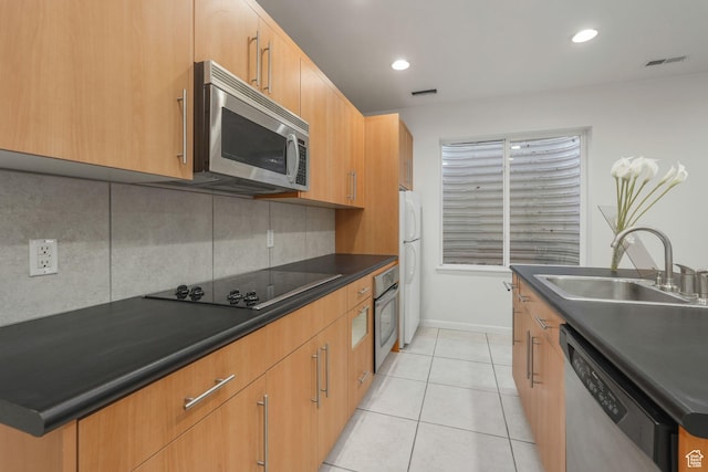 4554 W Birdie Way S, Jordan, UT 84009 - kitchen with stainless steel appliances, a sink, decorative backsplash, dark countertops, and light tile patterned floors