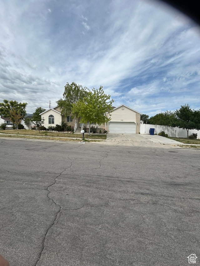 3086 S Fernbush Dr, Magna, UT 84044 - view of property hidden behind natural elements with concrete driveway and a garage