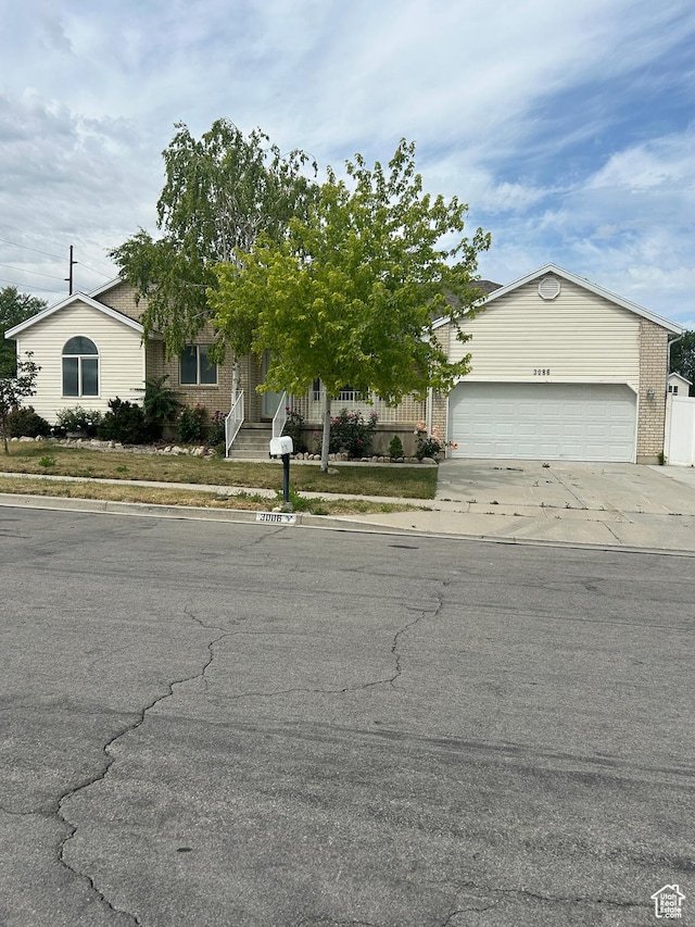 3086 S Fernbush Dr, Magna, UT 84044 - obstructed view of property with concrete driveway, an attached garage, and brick siding