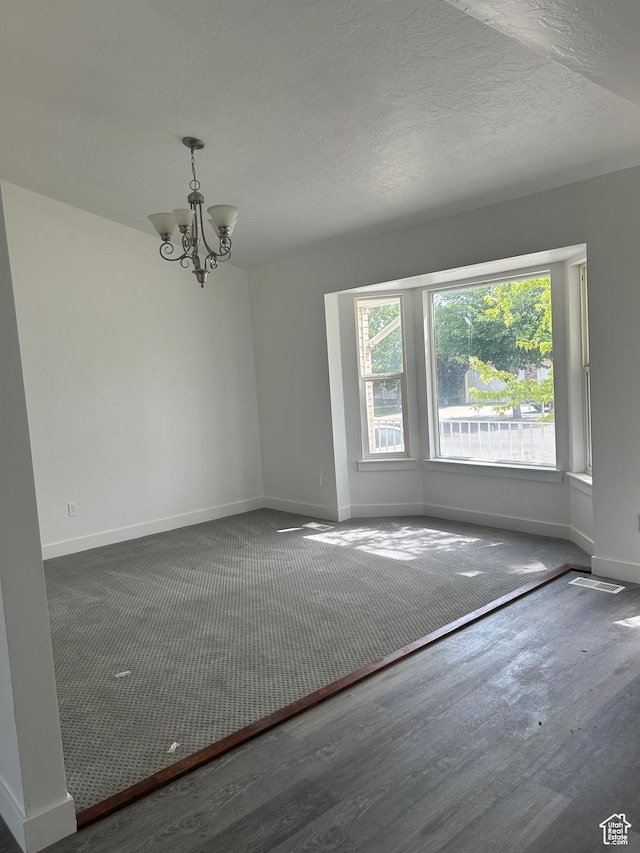 3086 S Fernbush Dr, Magna, UT 84044 - empty room with plenty of natural light, baseboards, a chandelier, wood finished floors, and a textured ceiling