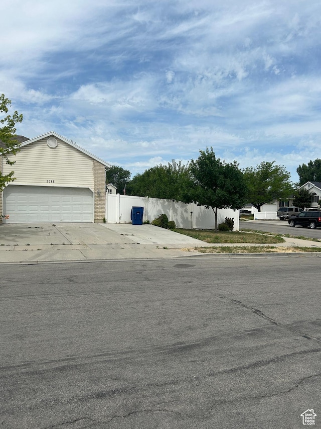 3086 S Fernbush Dr, Magna, UT 84044 - view of side of home with driveway, an attached garage, and brick siding