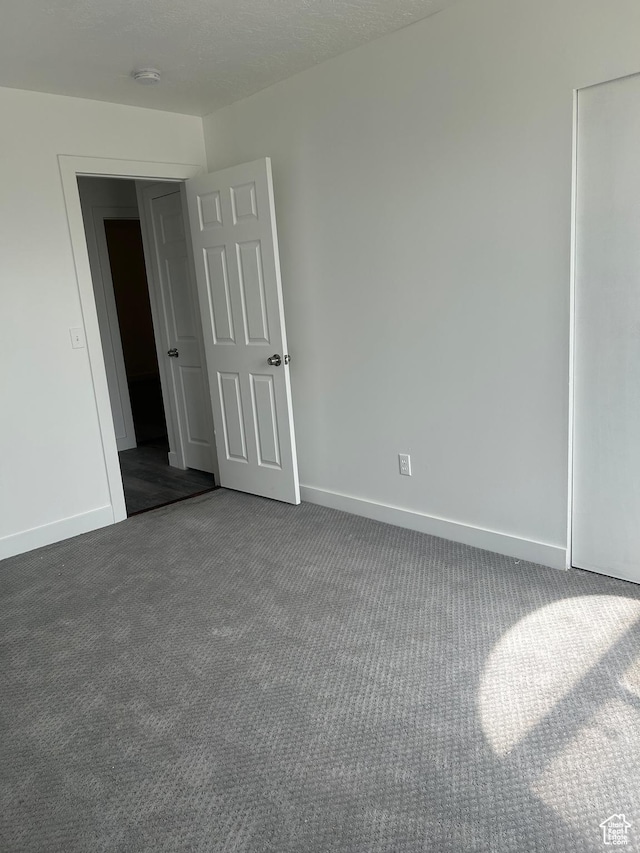 3086 S Fernbush Dr, Magna, UT 84044 - empty room featuring dark colored carpet, baseboards, and a smoke detector