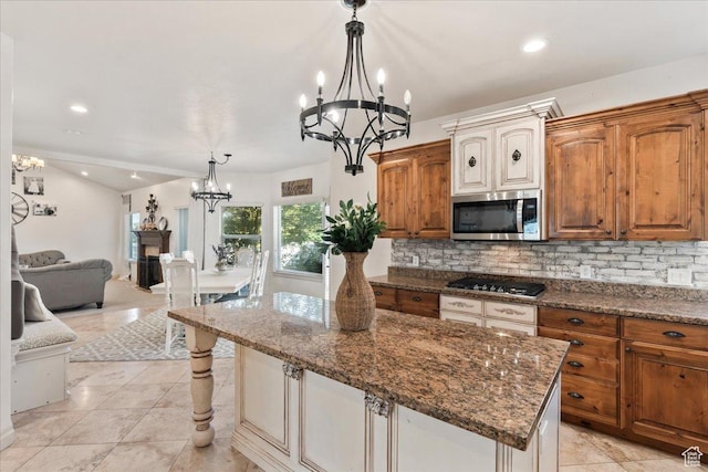 521 W Western Dr S, Kaysville, UT 84037 - kitchen with stainless steel microwave, a chandelier, gas stovetop, decorative backsplash, and dark stone counters