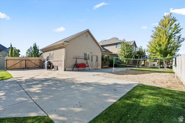 521 W Western Dr S, Kaysville, UT 84037 - back of property with volleyball court, a gate, and stucco siding