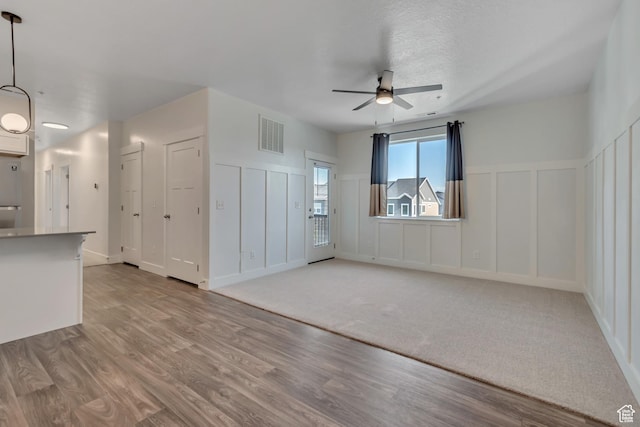 3919 W 1530 N Unit 202, Lehi, UT 84043 - unfurnished living room with a decorative wall, ceiling fan, wood finished floors, and a wainscoted wall