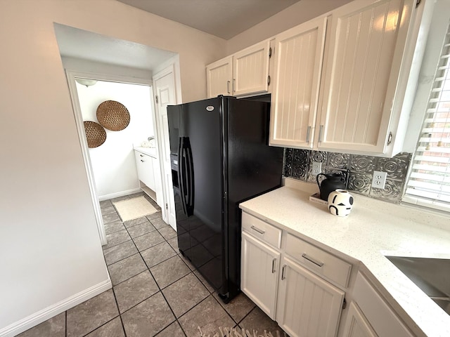 206 E Handcart Way, Sandy, UT 84070 - kitchen with black fridge, white cabinetry, light tile patterned floors, baseboards, and light stone countertops
