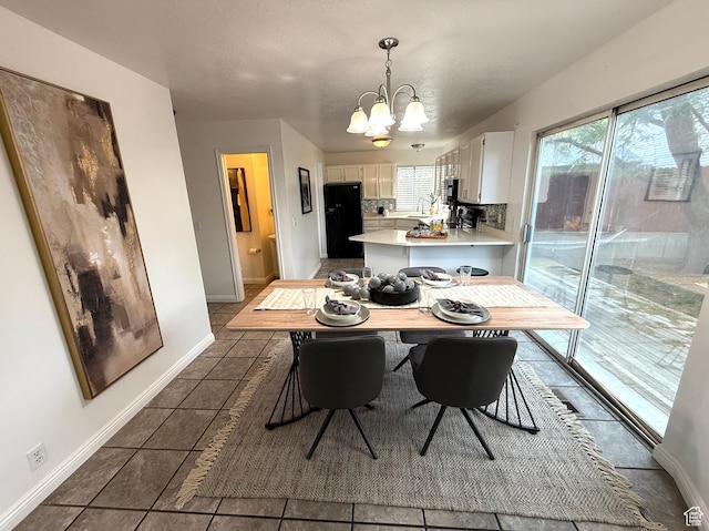 206 E Handcart Way, Sandy, UT 84070 - dining space featuring a chandelier, dark tile patterned flooring, and baseboards