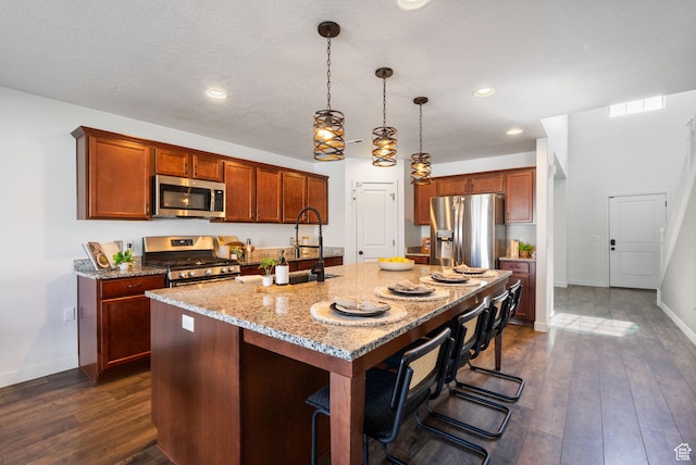 3456 S Linden Way, Syracuse, UT 84075 - kitchen featuring appliances with stainless steel finishes, a center island with sink, light stone countertops, dark wood finished floors, and recessed lighting